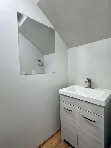 Bathroom featuring a vanity with wood-finish cabinetry, integrated sink, and brushed nickel faucet