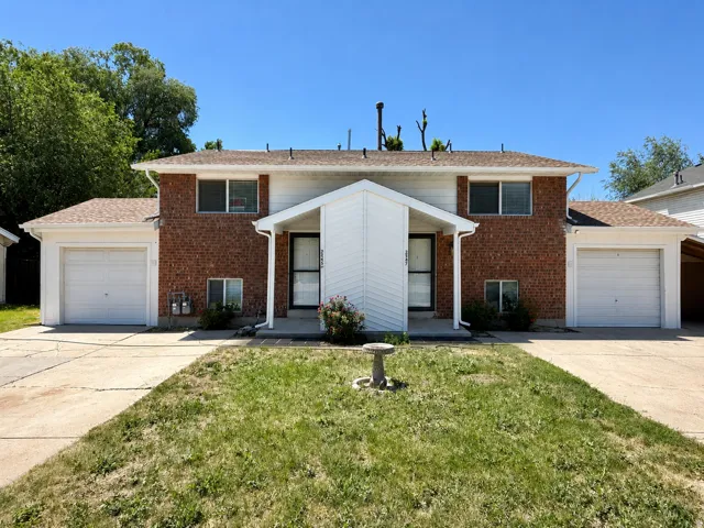 Duplex exterior featuring a brick and white siding facade