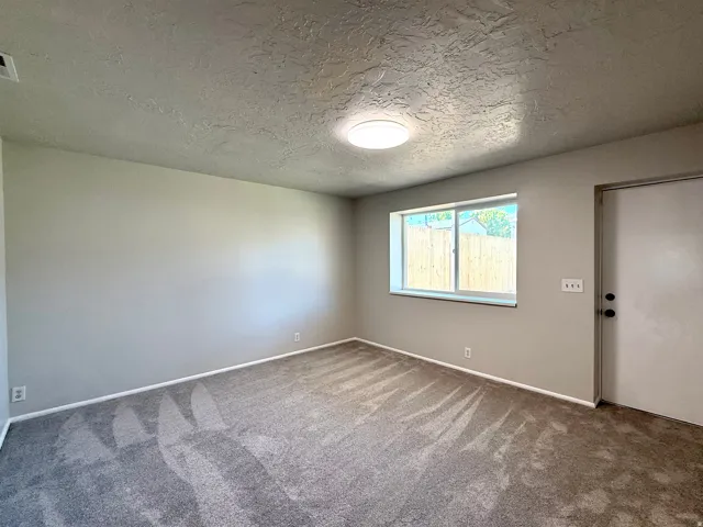 Neutral tone wall paint complements the gray carpet flooring
