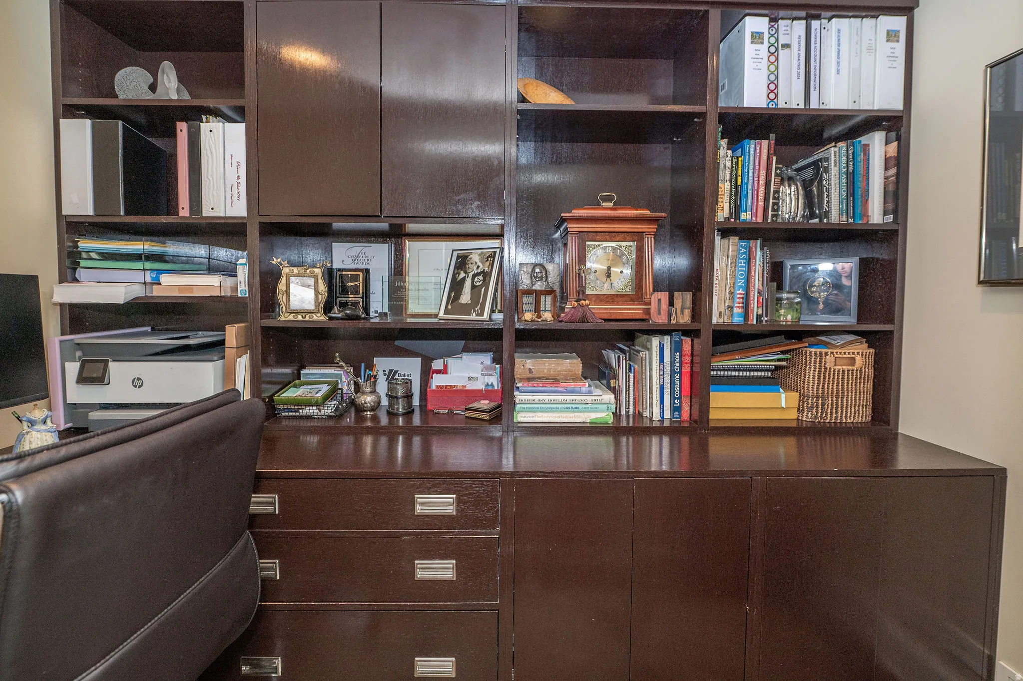 Integrated dark wood-finish cabinetry featuring open shelving, storage cabinets, and multiple drawers