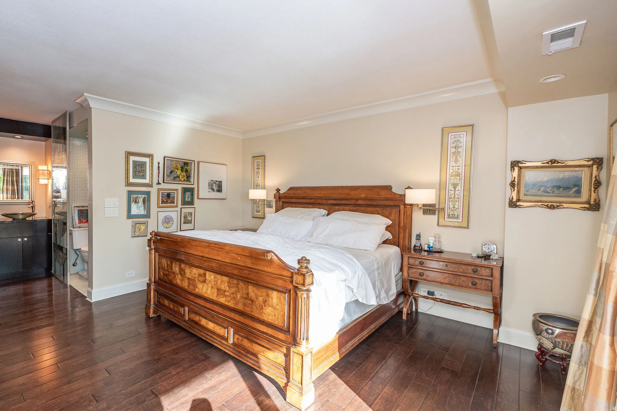 Hardwood flooring throughout, crown molding, built-in sconce lighting, and a vanity with an integrated basin sink