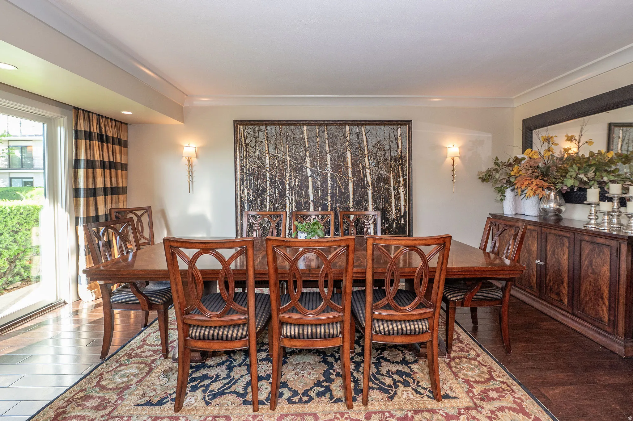 Formal dining space featuring wood-finish flooring, a large area rug, and crown molding