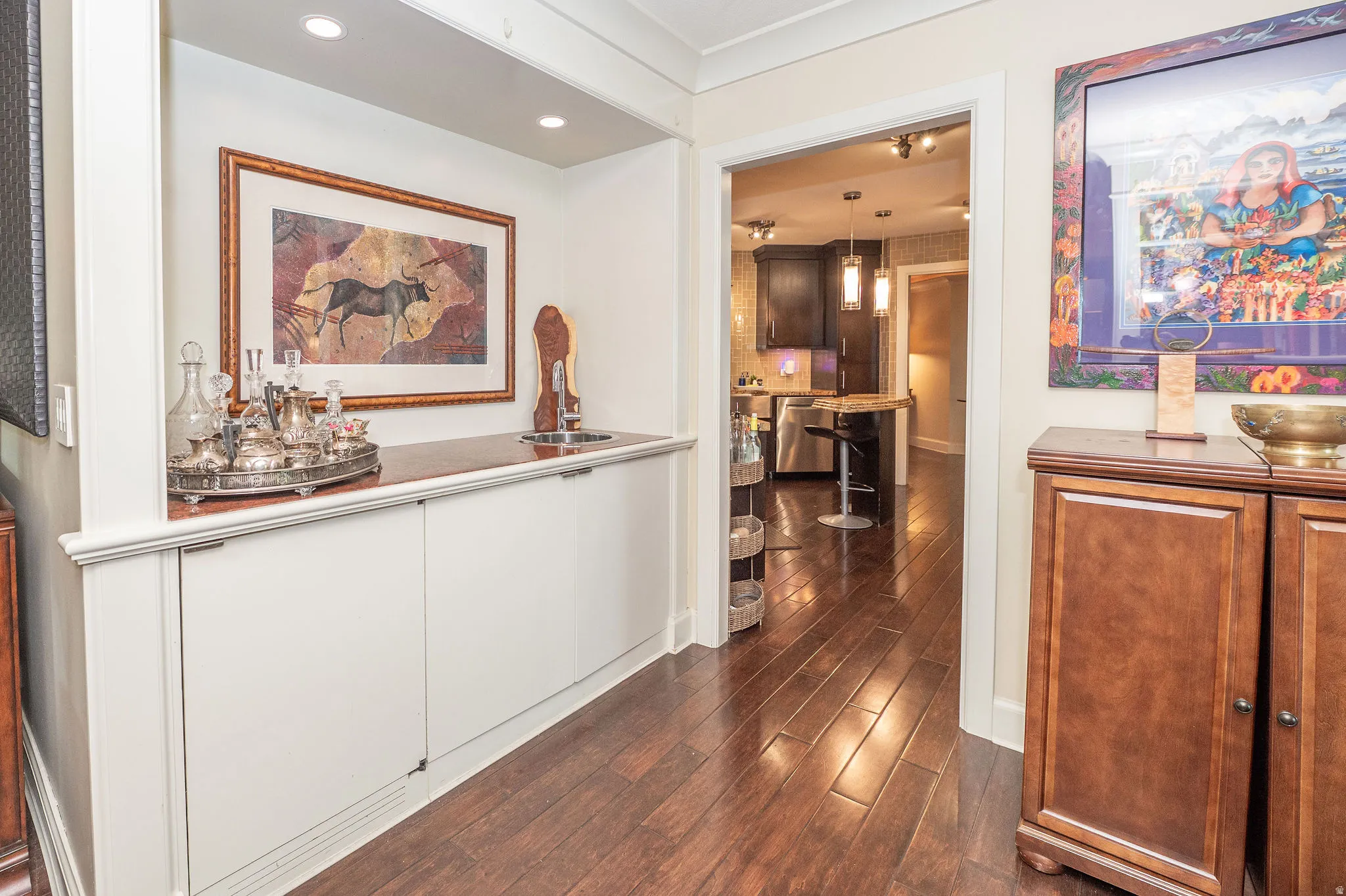 Built-in wet bar featuring a polished countertop, undermount sink, and recessed lighting