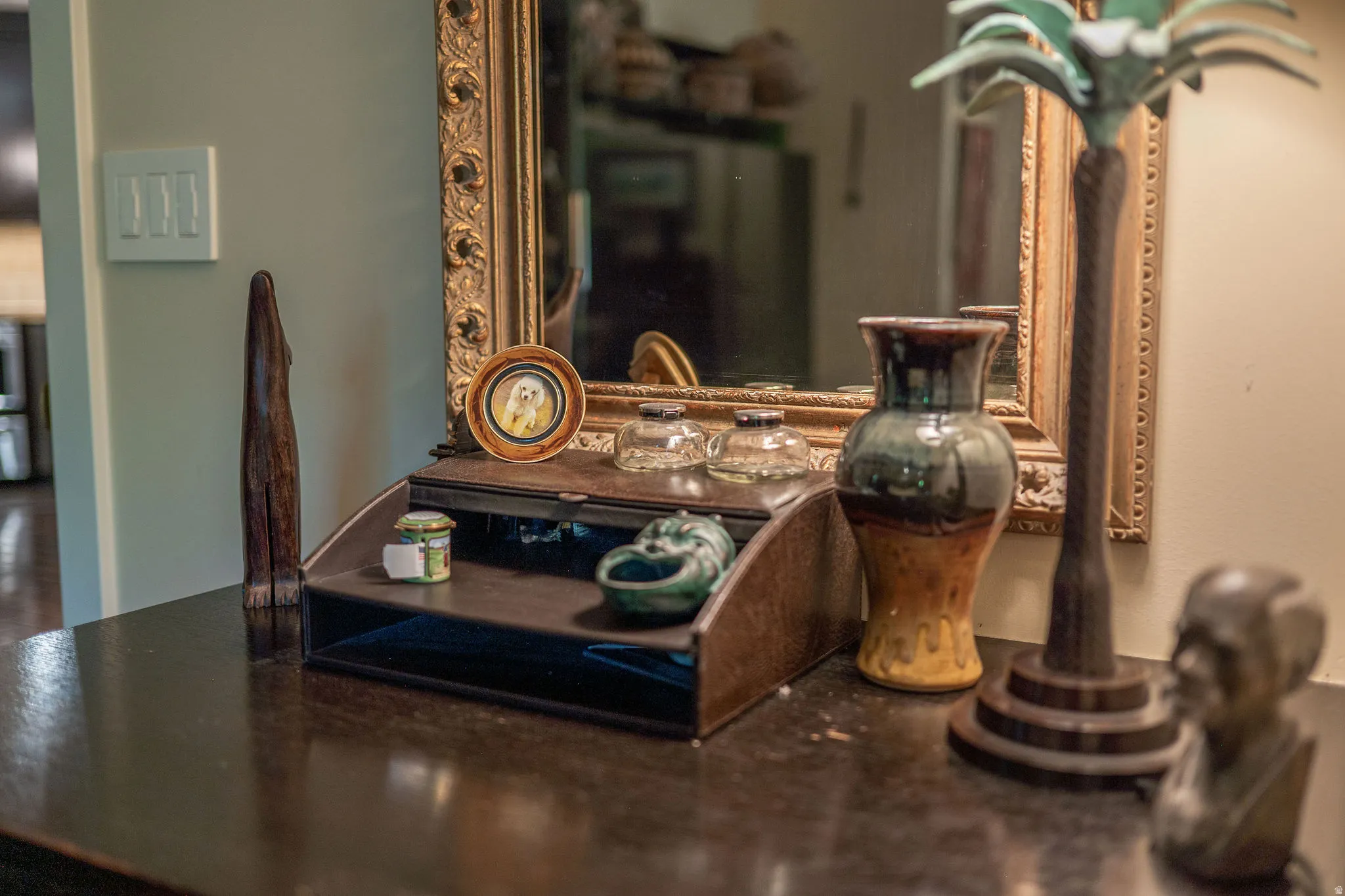 Dark wood-finish console table with an ornate framed mirror