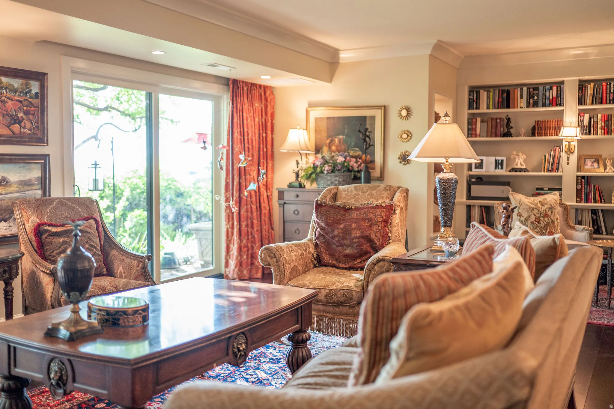 Living area featuring wood-finish flooring, built-in shelving, crown molding, a sliding glass door, and recessed lighting