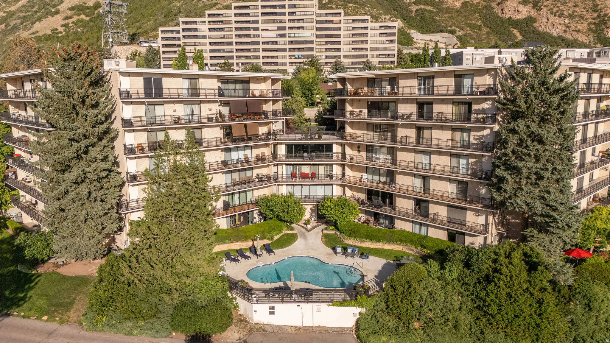 Modern multi-story building featuring balconies and a central outdoor pool