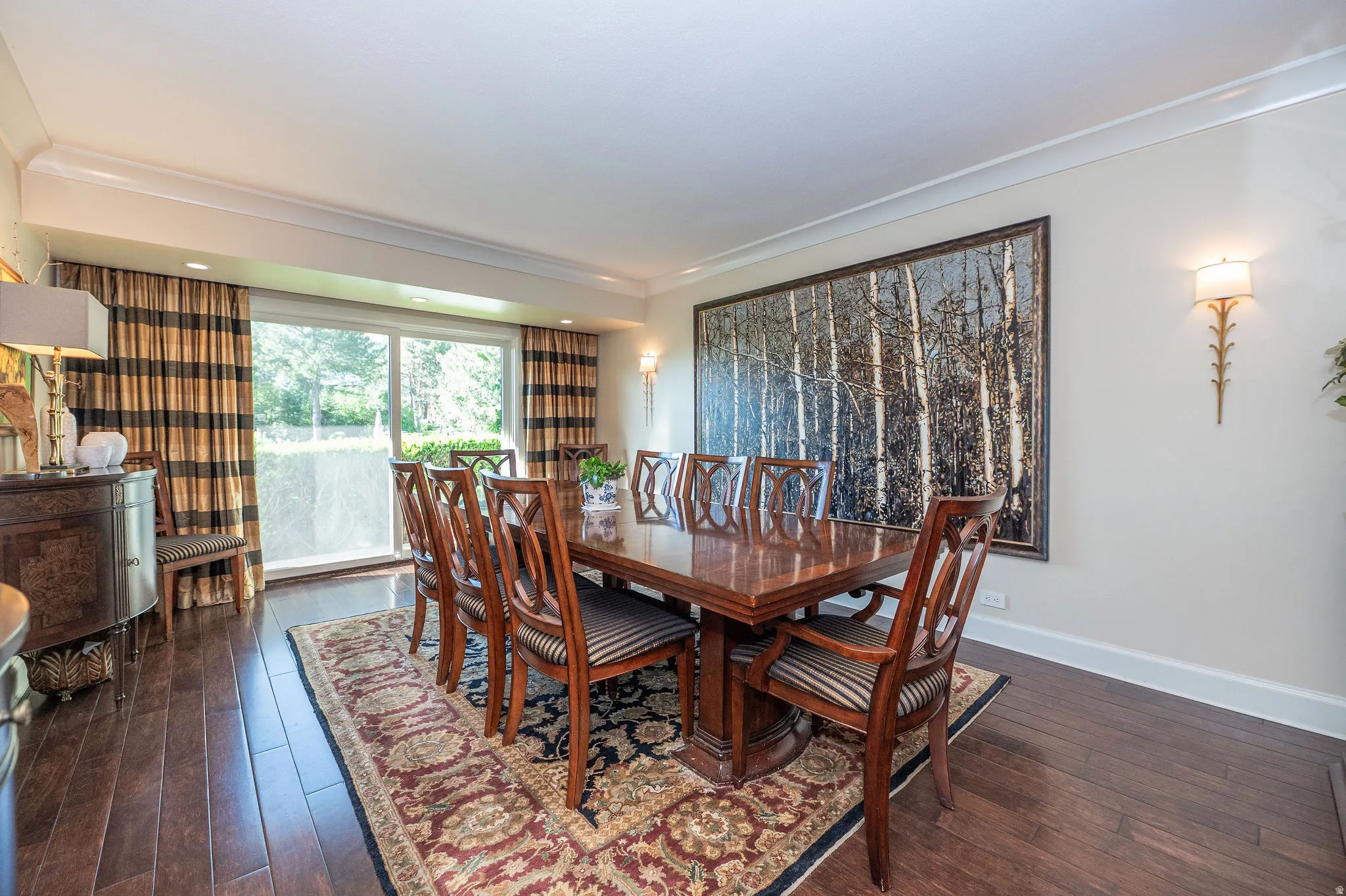 Formal dining area featuring rich wood-finish flooring and a large sliding glass door