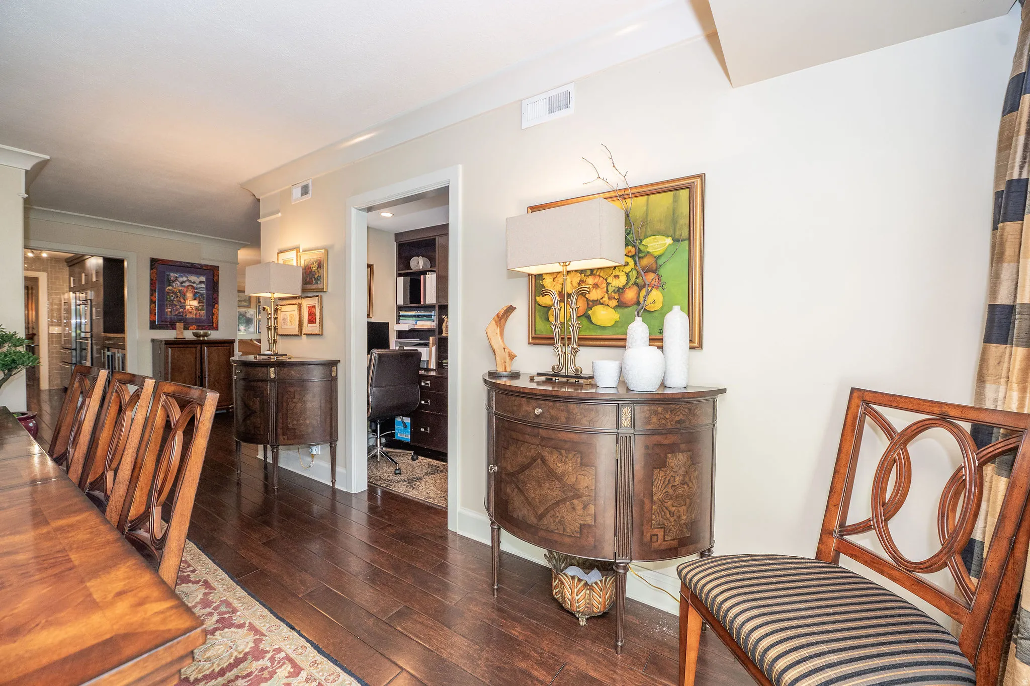 Hardwood flooring extends throughout this interior space, featuring crown molding and a recessed doorway