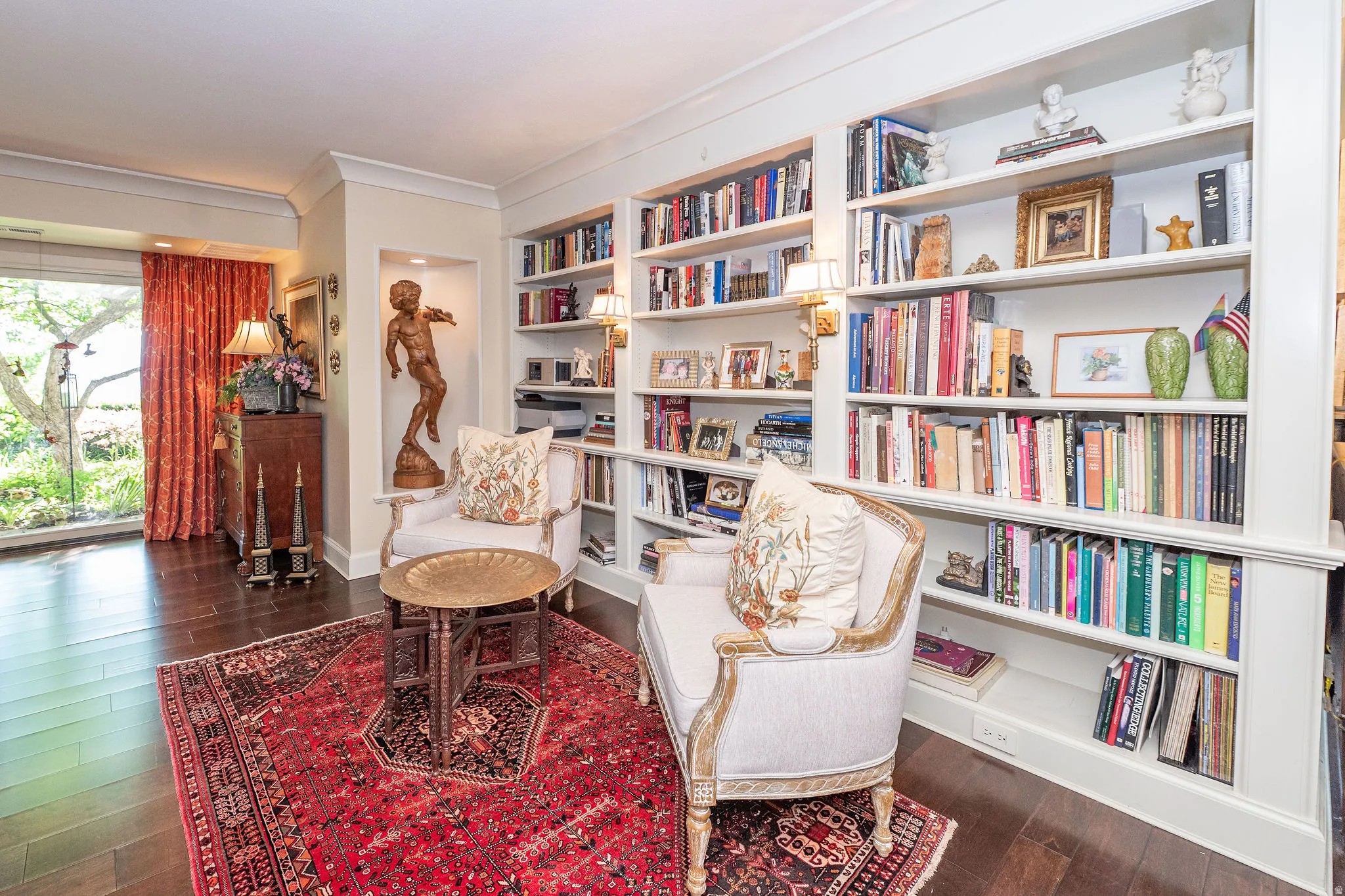 Built-in white shelving with wall sconces