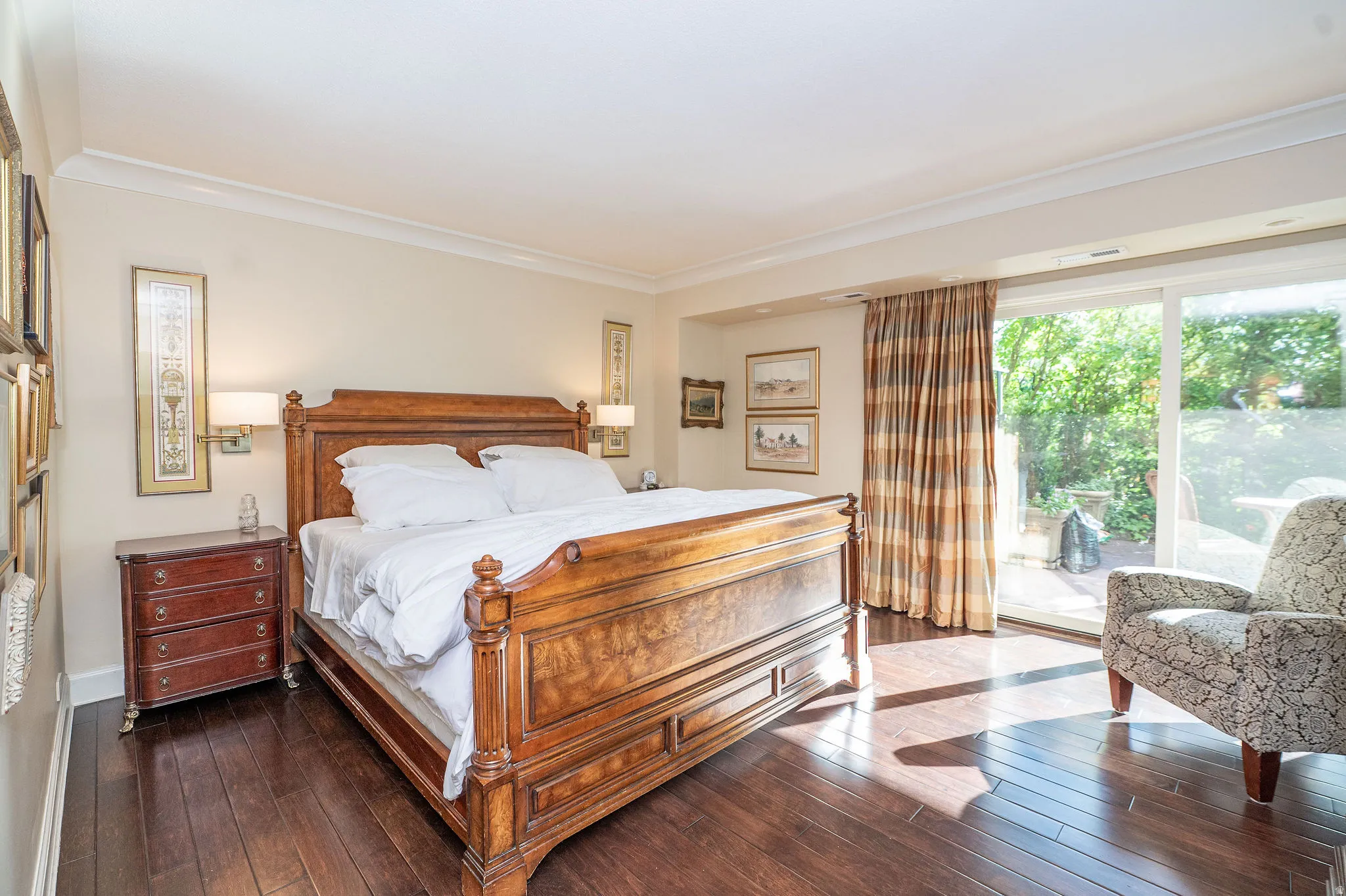 Bedroom featuring wood-finish flooring, crown molding, and direct access to an outdoor patio via sliding glass doors