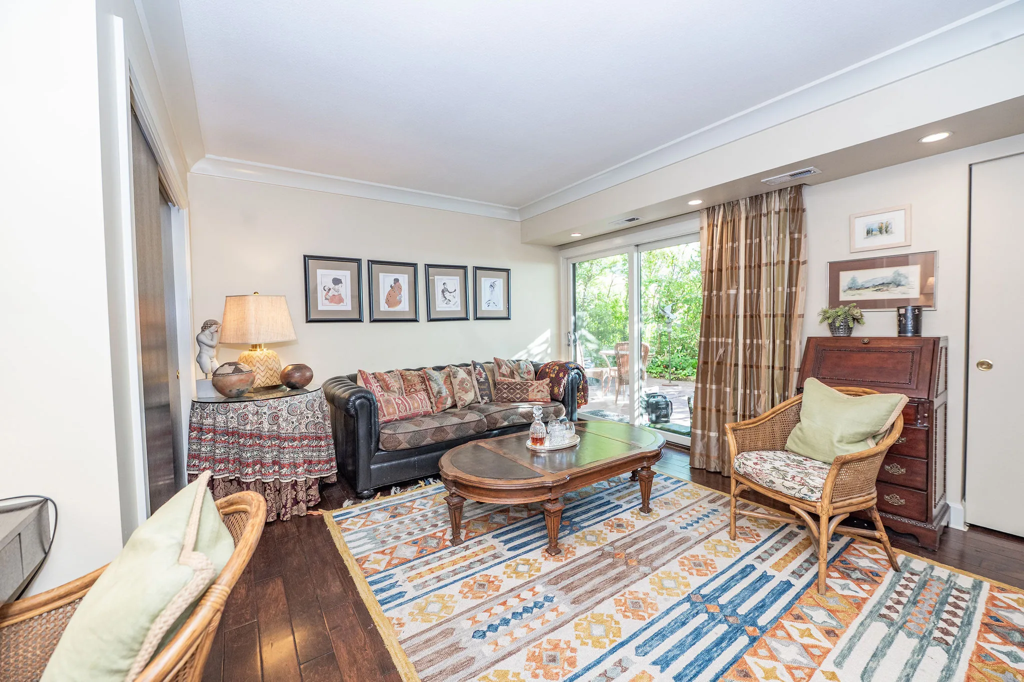 Spacious living area featuring wood-finish flooring, recessed lighting, and crown molding