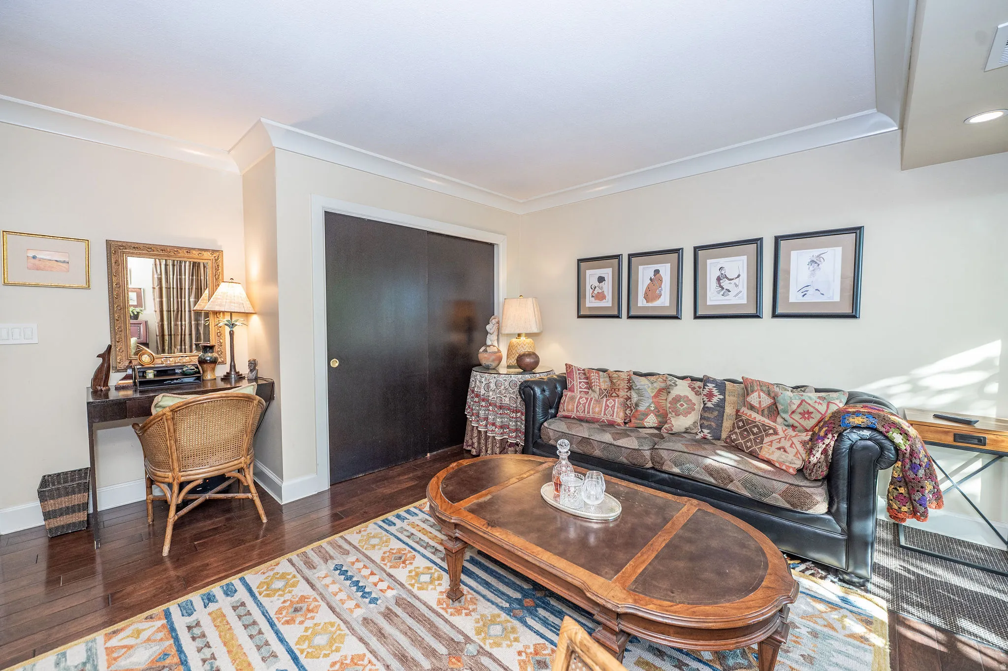 Expansive interior room featuring dark wood-finish flooring, white crown molding, and a built-in closet with dark sliding doors