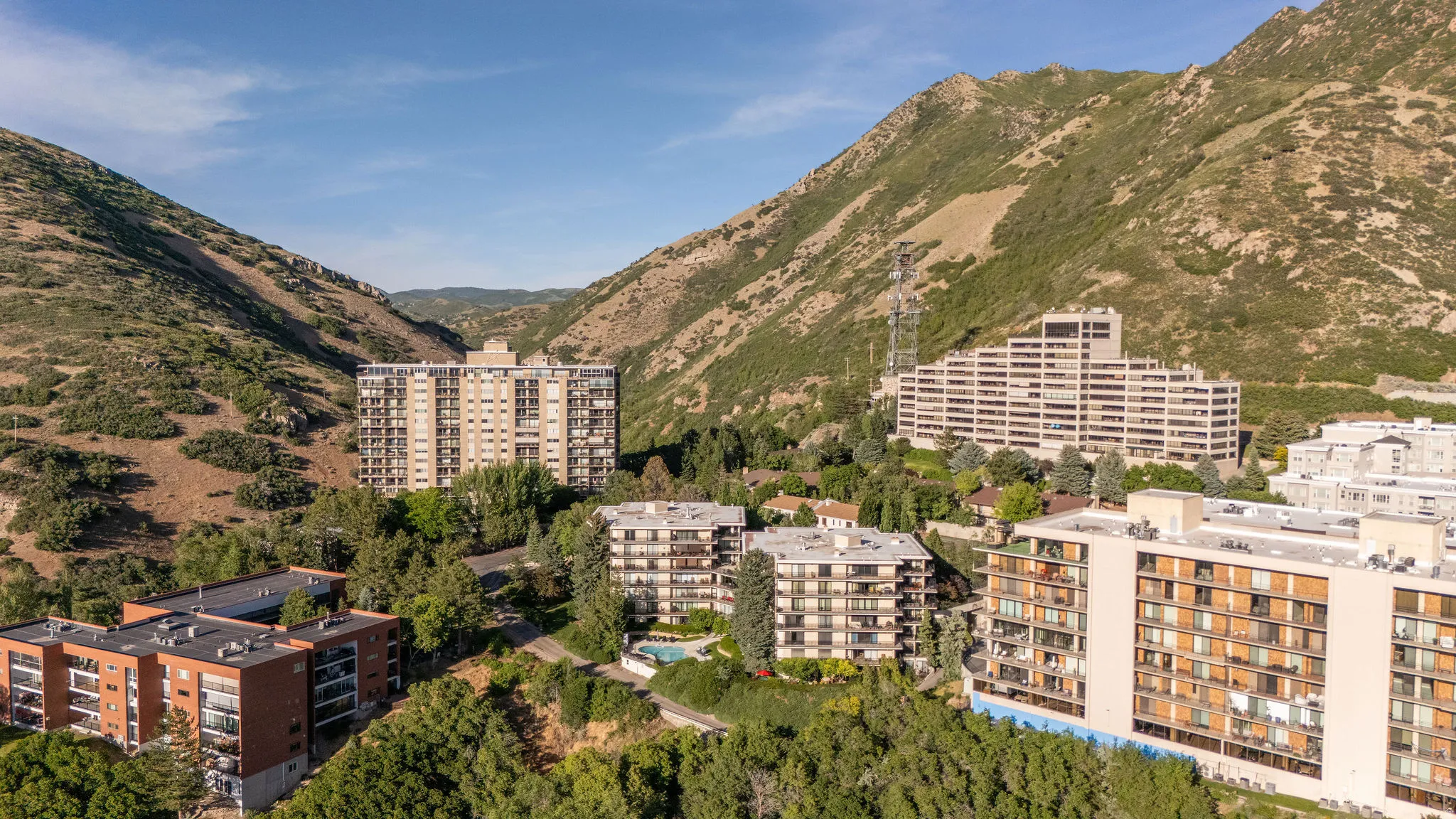Aerial perspective showcasing multiple residential buildings nestled within a mountainous landscape
