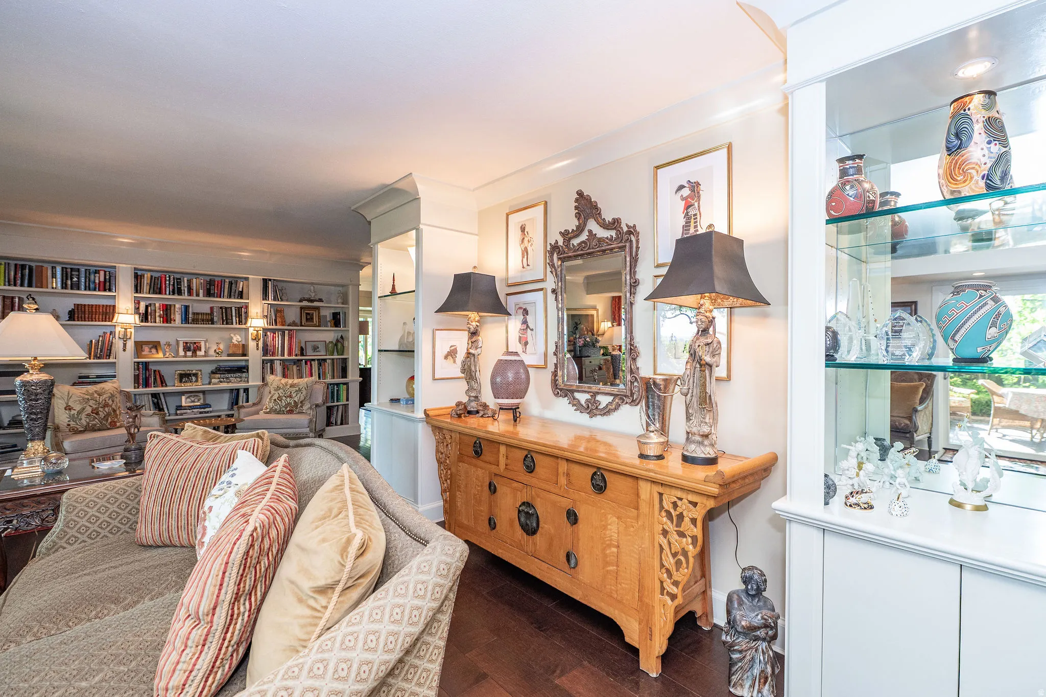 Custom built-in bookcases with sconce lighting frame a comfortable seating area