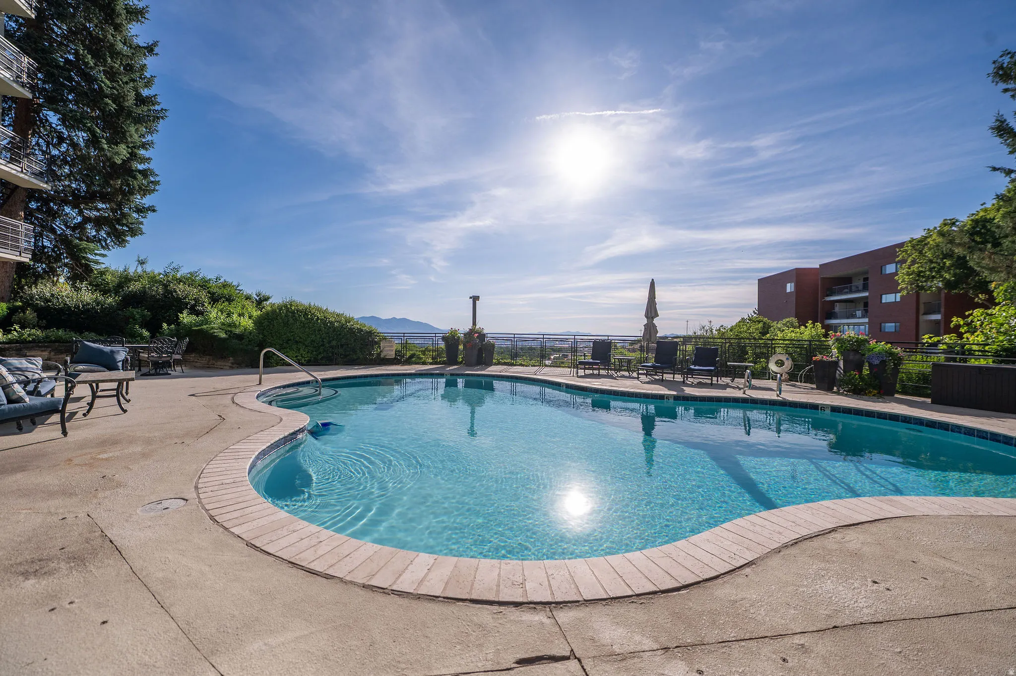 Resort-style pool area with a curvilinear design and brick coping