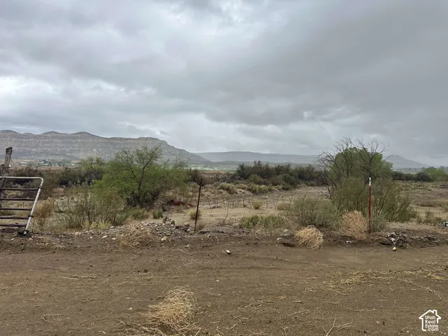 Expansive desert landscape featuring distant mountain ranges and scattered vegetation