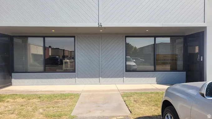 Commercial storefront with two large display windows, a recessed entry, and light gray siding