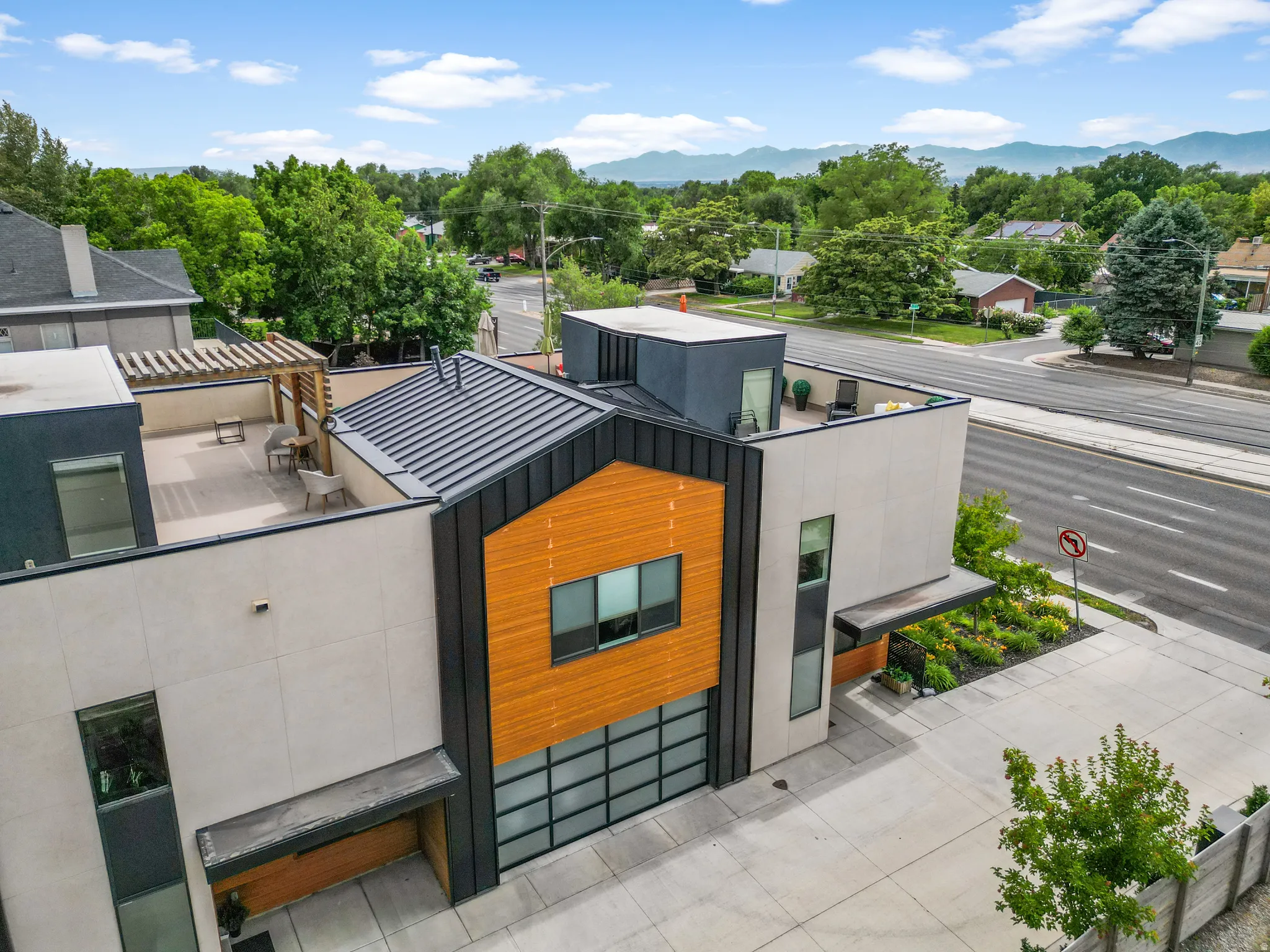 Modern architectural design featuring a multi-level structure with a metal roof and wood-look siding accents