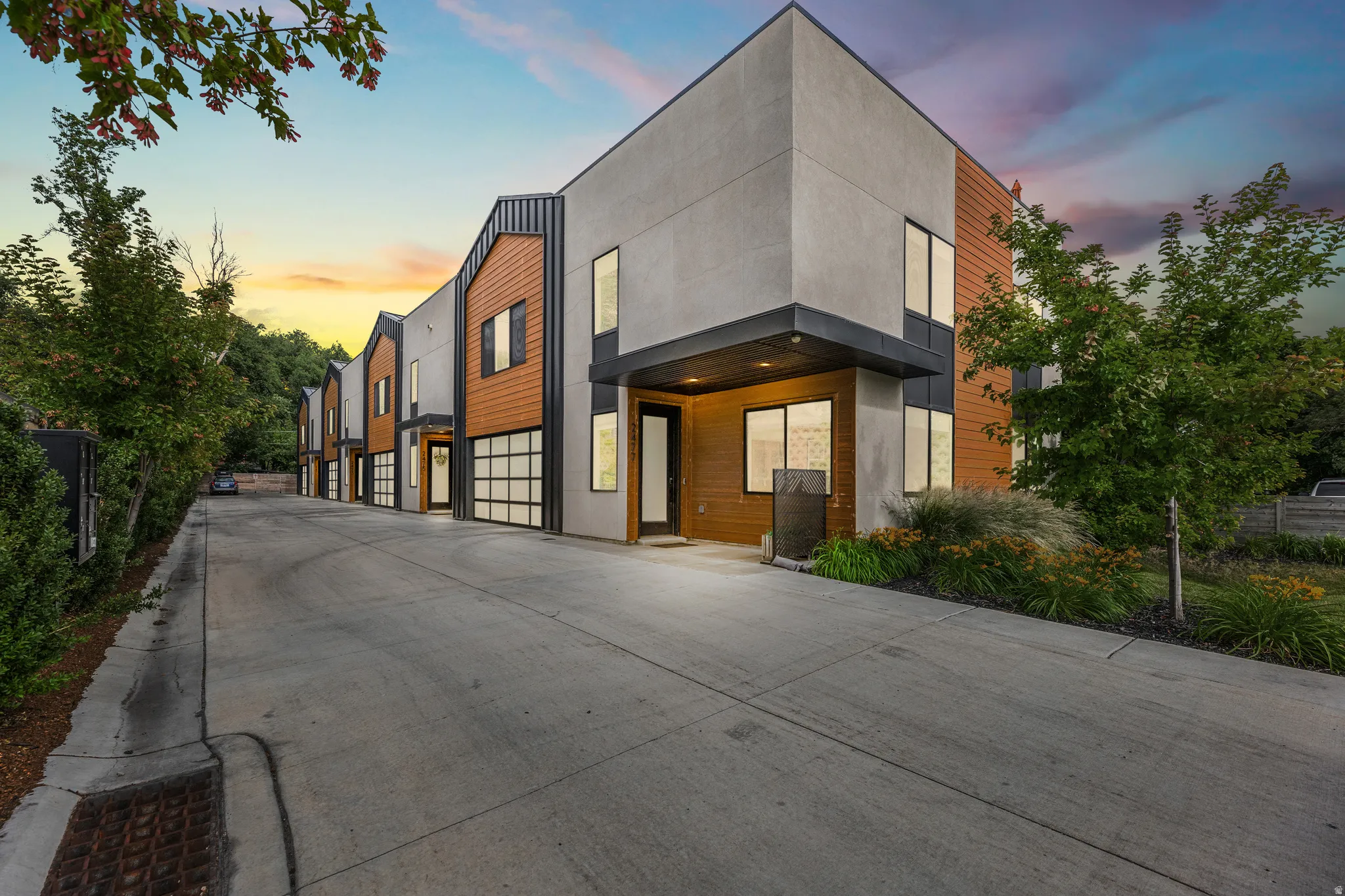 Contemporary townhome exterior featuring a stucco and wood-panel facade