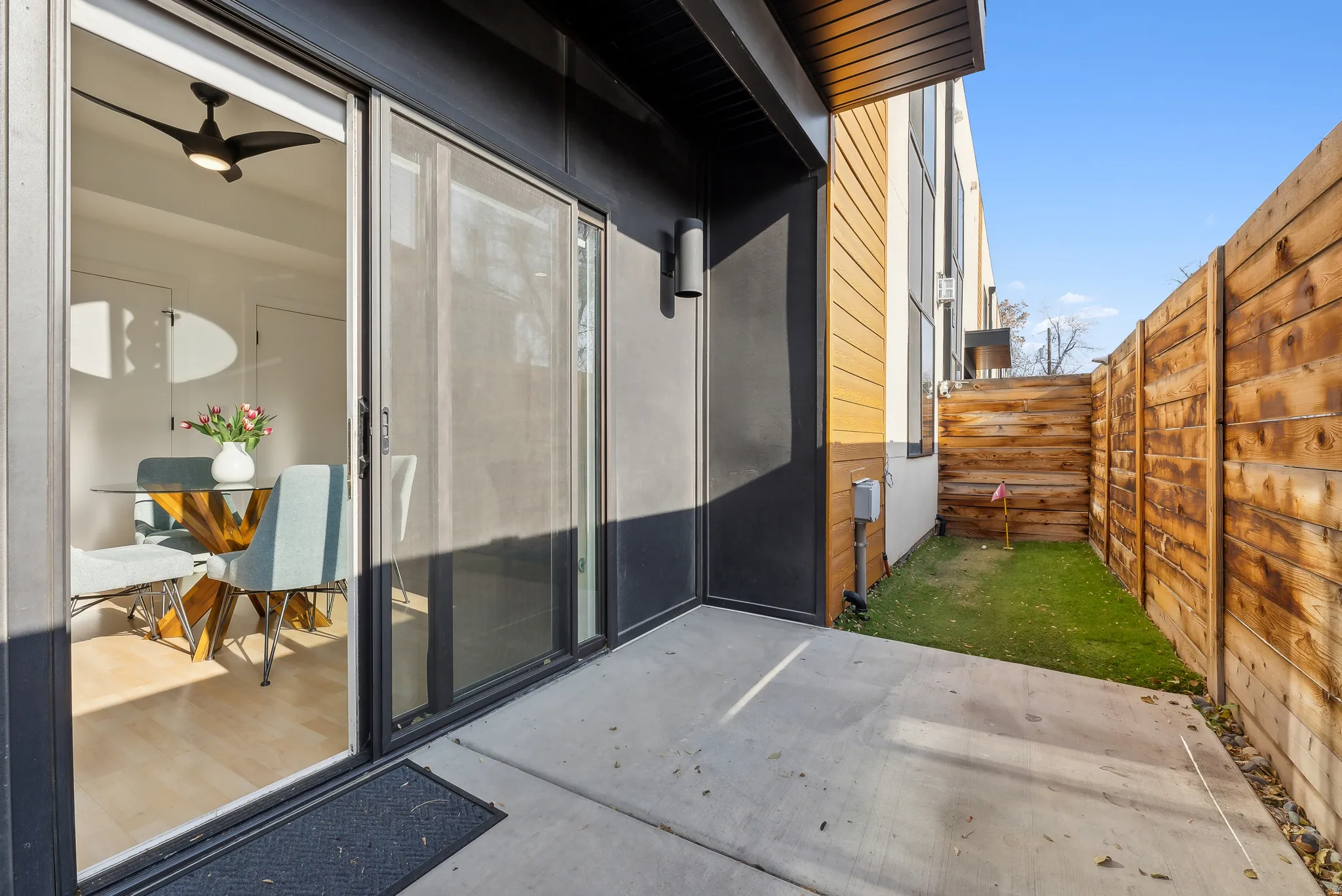 Outdoor patio space featuring concrete flooring and a privacy fence