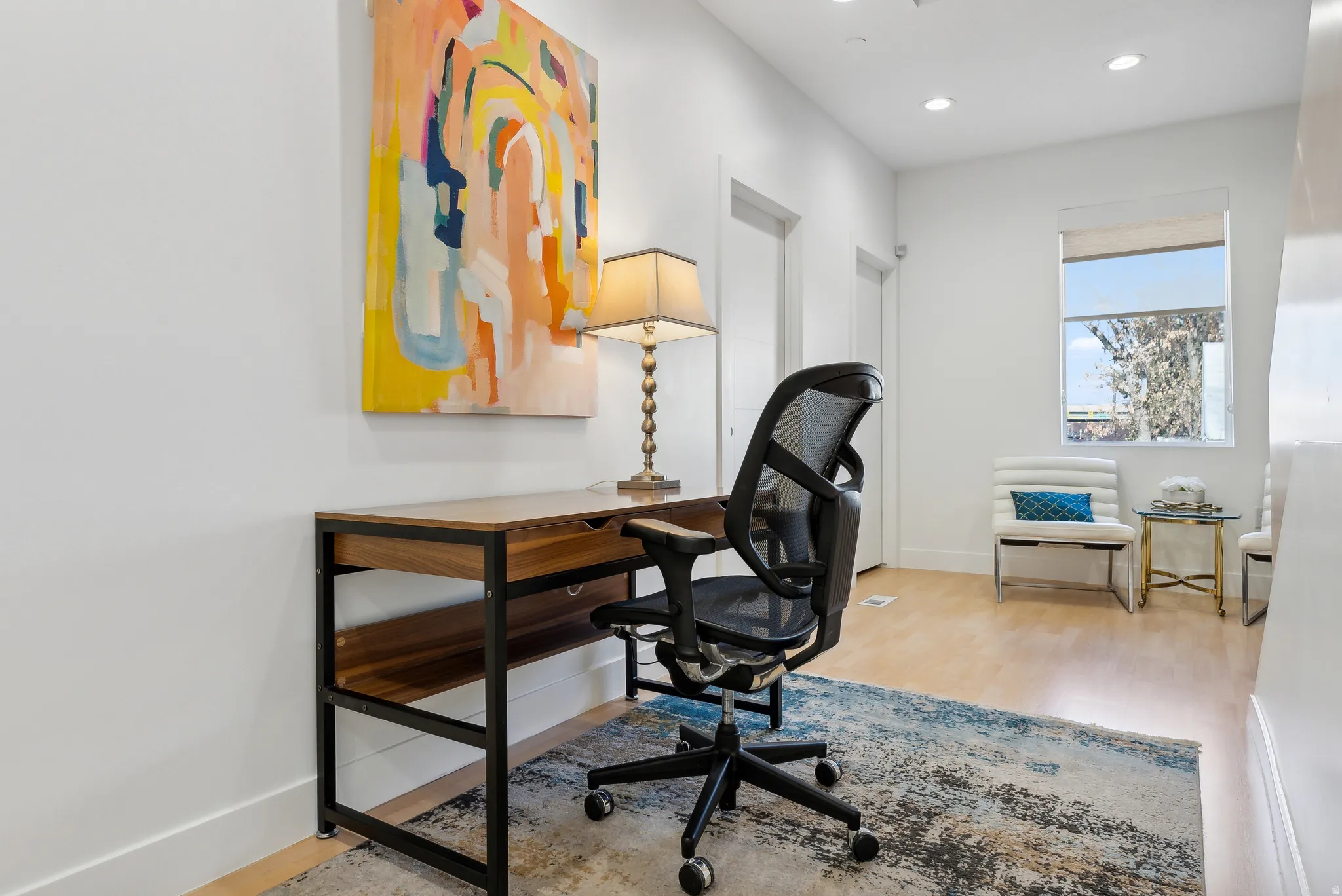 Dedicated workspace featuring light wood-finish flooring and recessed lighting