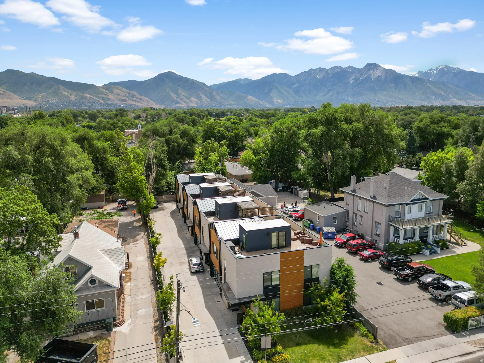 Modern multi-level townhomes with flat roofs and a mountain backdrop