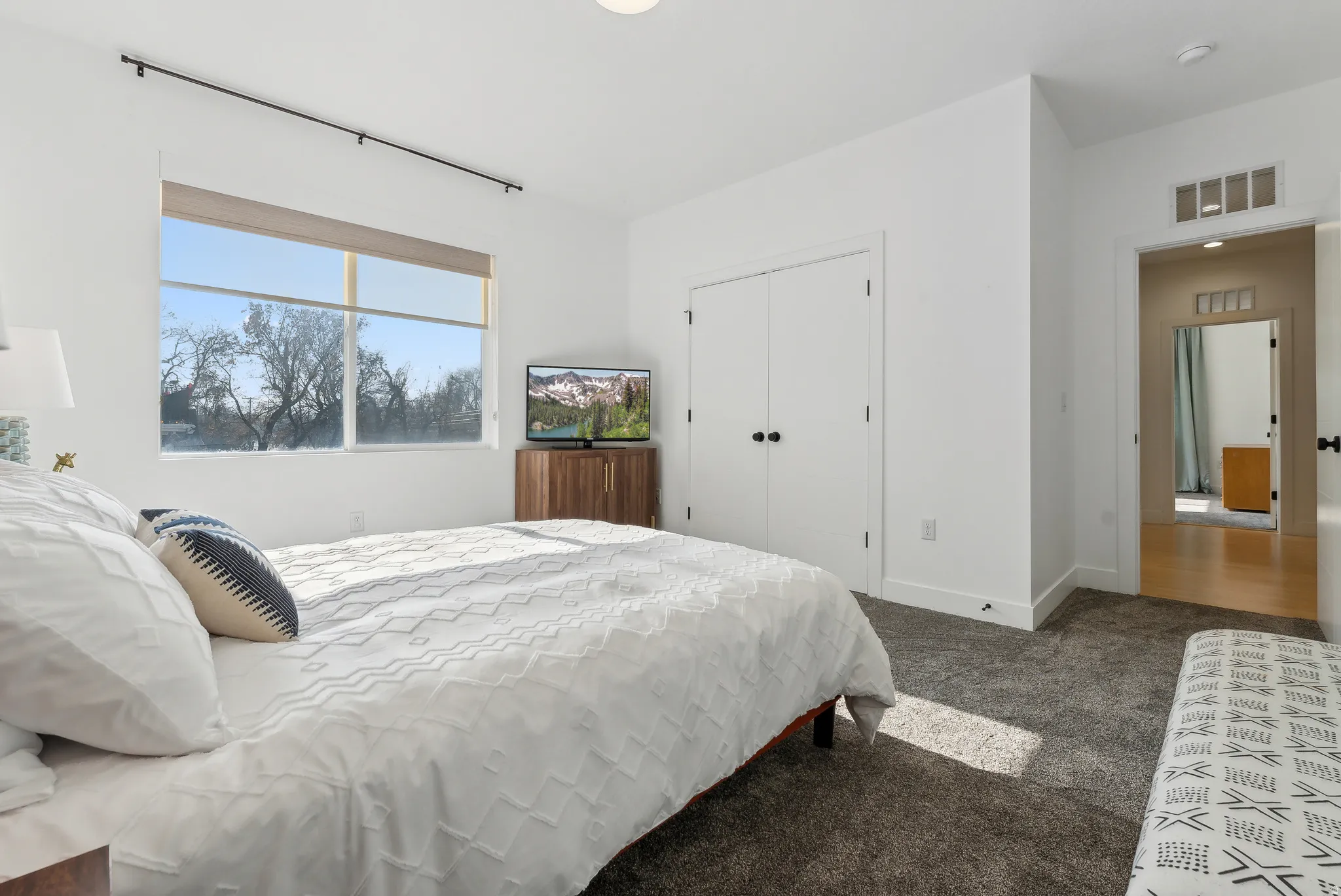Bedroom featuring a large window, white walls, and dark gray carpet