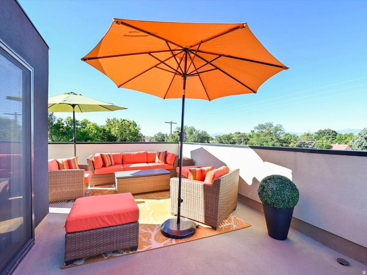 Expansive rooftop deck featuring a solid privacy wall and a clear sky backdrop