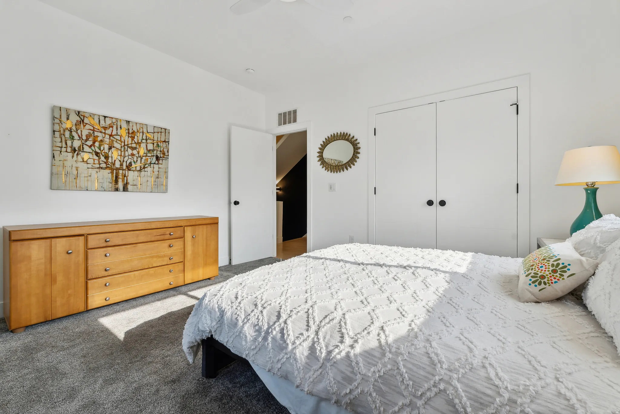 White walls frame this bedroom with gray carpet flooring