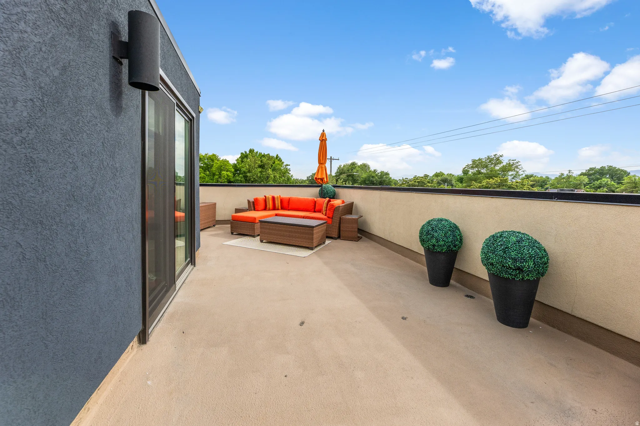 Spacious rooftop deck featuring concrete flooring and a perimeter wall