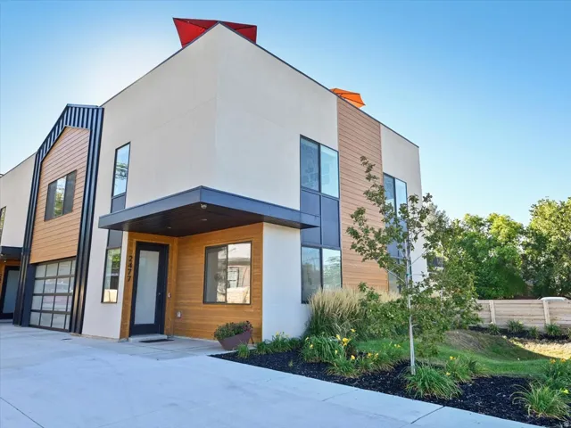 Contemporary exterior featuring a flat roofline, cream stucco, and horizontal wood-finish siding