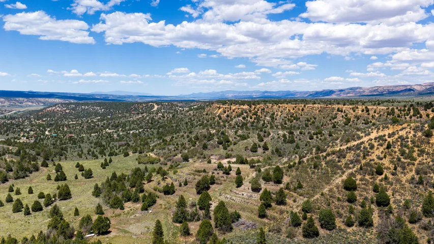 Expansive natural landscape featuring rolling terrain and distant mountain ranges