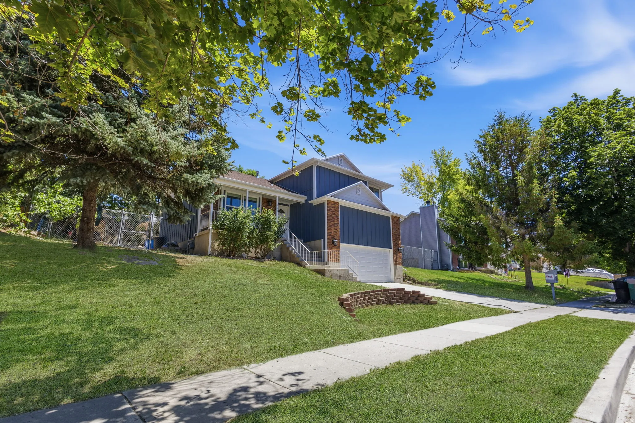 Blue exterior with contrasting brick accents and an attached garage