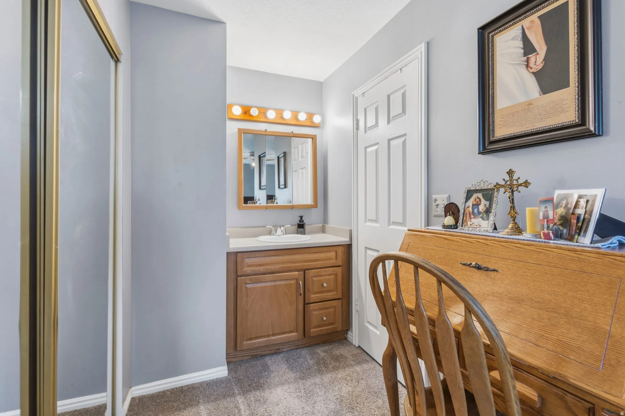 Bathroom vanity featuring a single basin sink, light-toned countertop, and wood-finish cabinetry