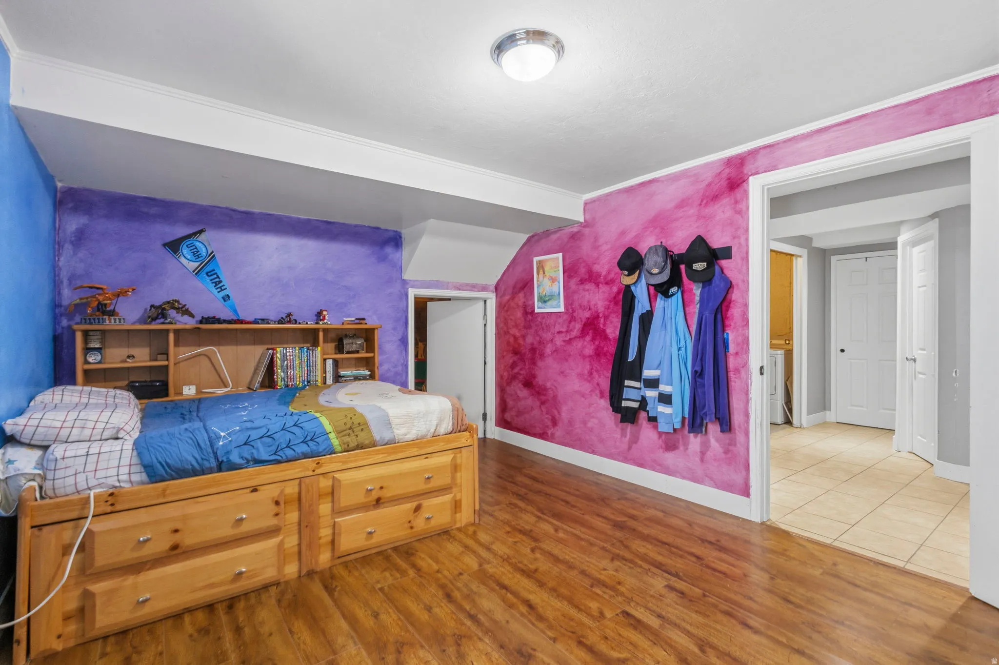 Room featuring wood-finish flooring, a flush-mount ceiling light, and crown molding