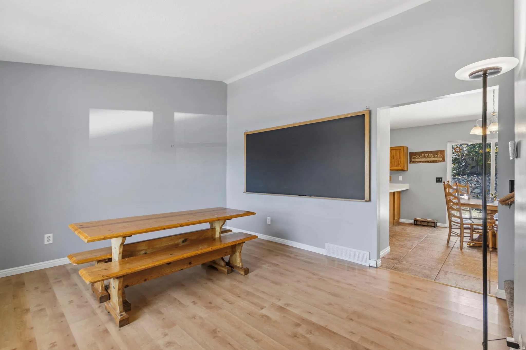 Light wood-finish flooring complements the light gray walls and white baseboards