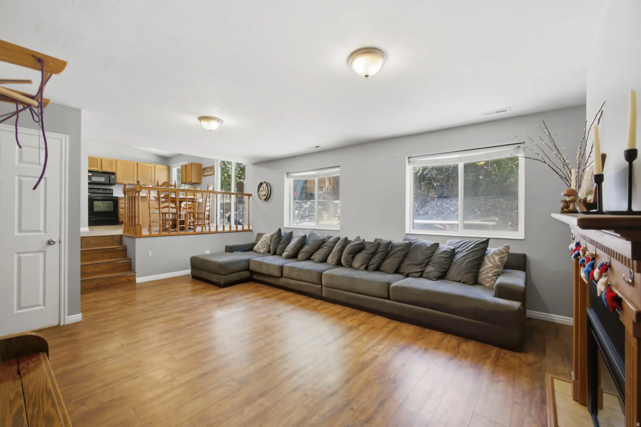 Spacious living area featuring wood-finish flooring, two windows, and a built-in fireplace