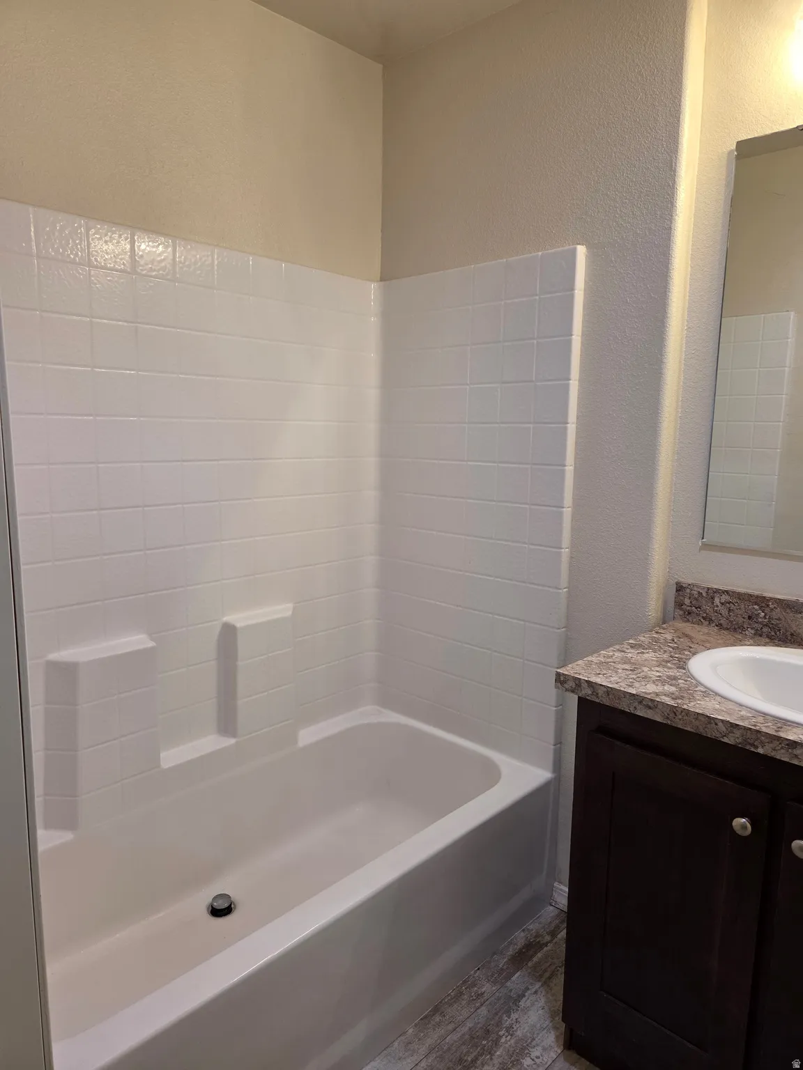 Full bathtub with white tiled surround in the master bedroom