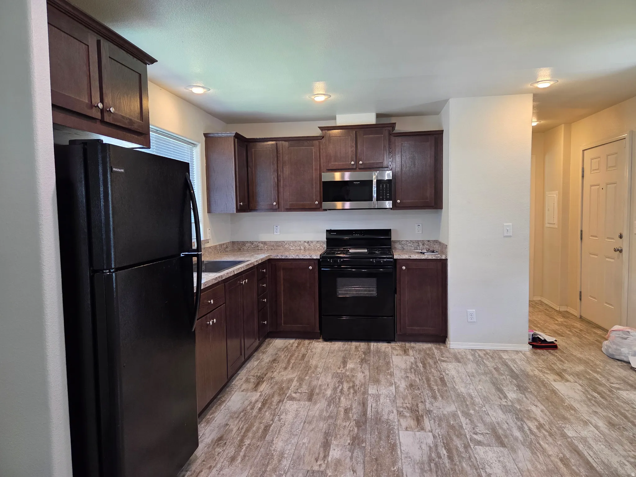 Kitchen featuring dark wood cabinetry, and speckled countertops