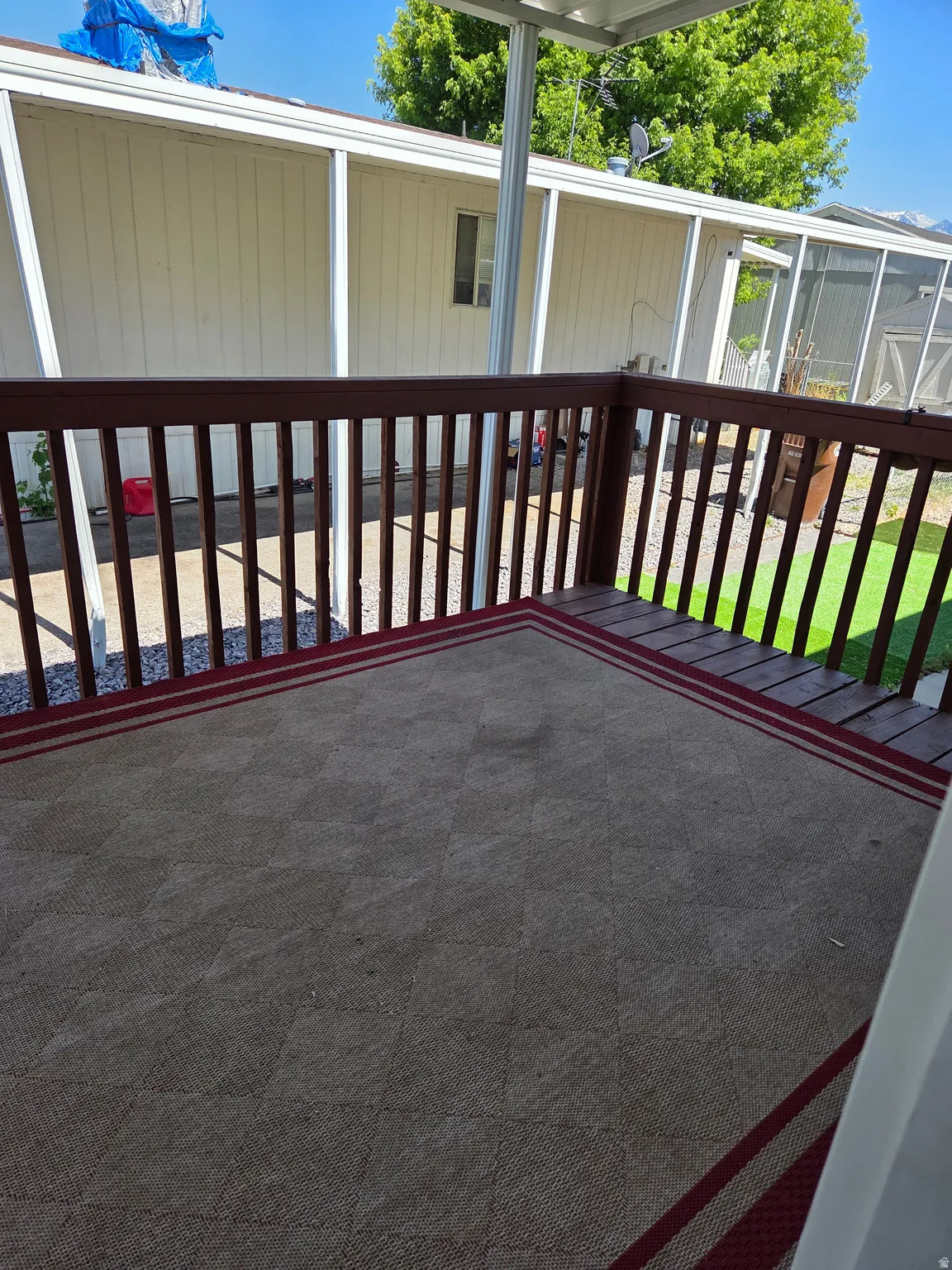 Outdoor deck with wood railings and a patterned floor covering
