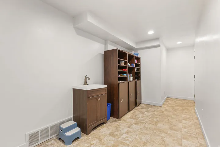 Utility area with a vanity sink, recessed lighting, and a built-in storage unit