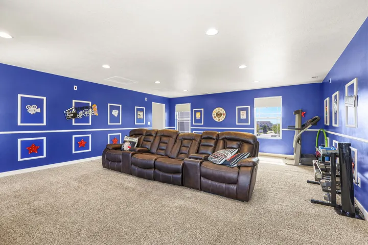 Spacious room featuring broadloom carpeting, recessed lighting, and bright blue walls with white dado rail molding