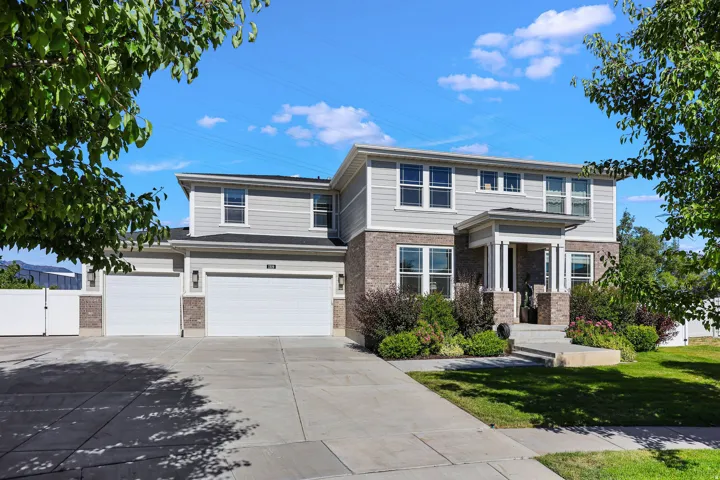 Traditional-style residence featuring a two-story design, a covered entry with columns, and a two-car garage