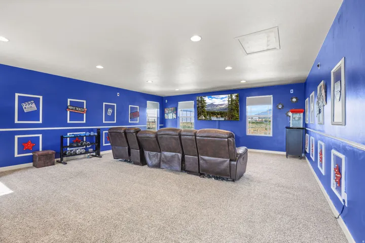Spacious entertainment room featuring blue walls with white trim and recessed lighting