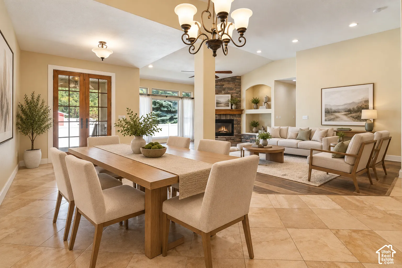 Open-concept area featuring stone-surround fireplace, dual built-in wall niches, multi-pane glass french doors, diagonal-patterned stone flooring, and recessed ceiling lighting