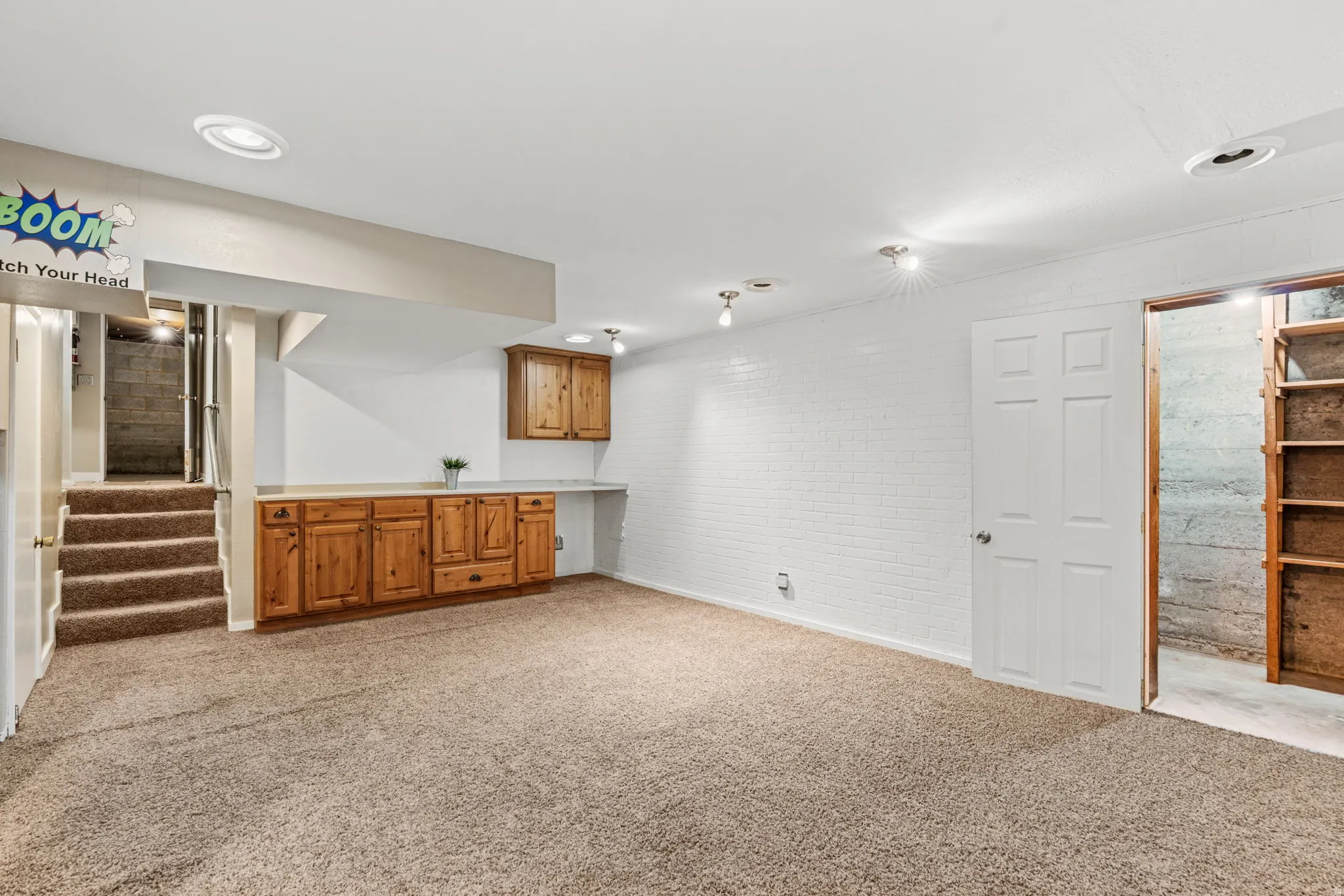 Carpeted room featuring built-in wood cabinetry, an integrated white countertop, and recessed ceiling lights
