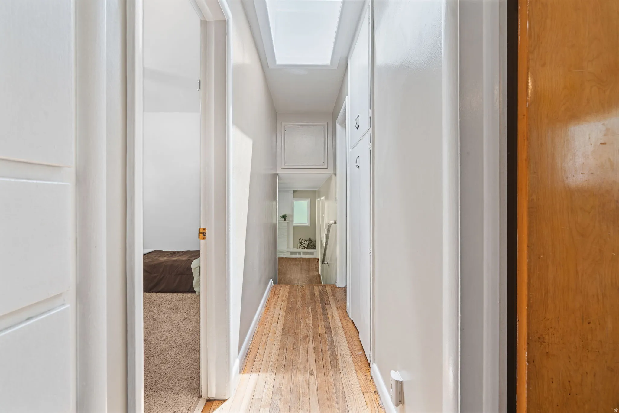 Hallway with skylight and built-in cabinetry