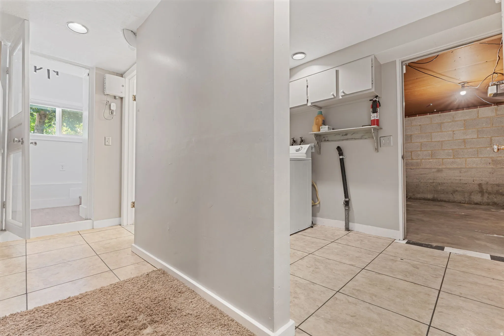 Laundry area featuring tile flooring, white cabinetry, a built-in shelf, and recessed lighting, hallway to the garden bedroom