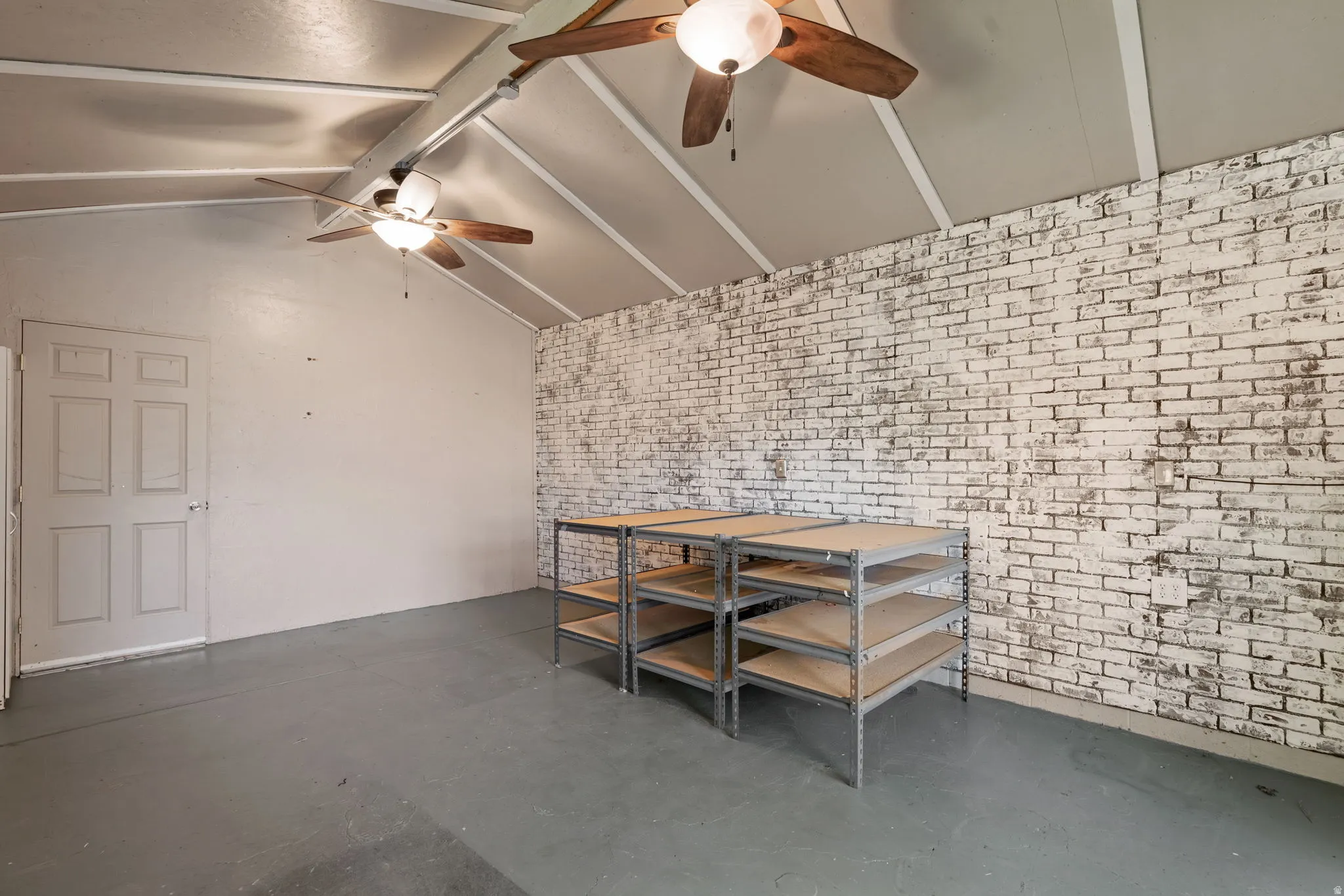 Vaulted ceiling with beams and two ceiling fans
