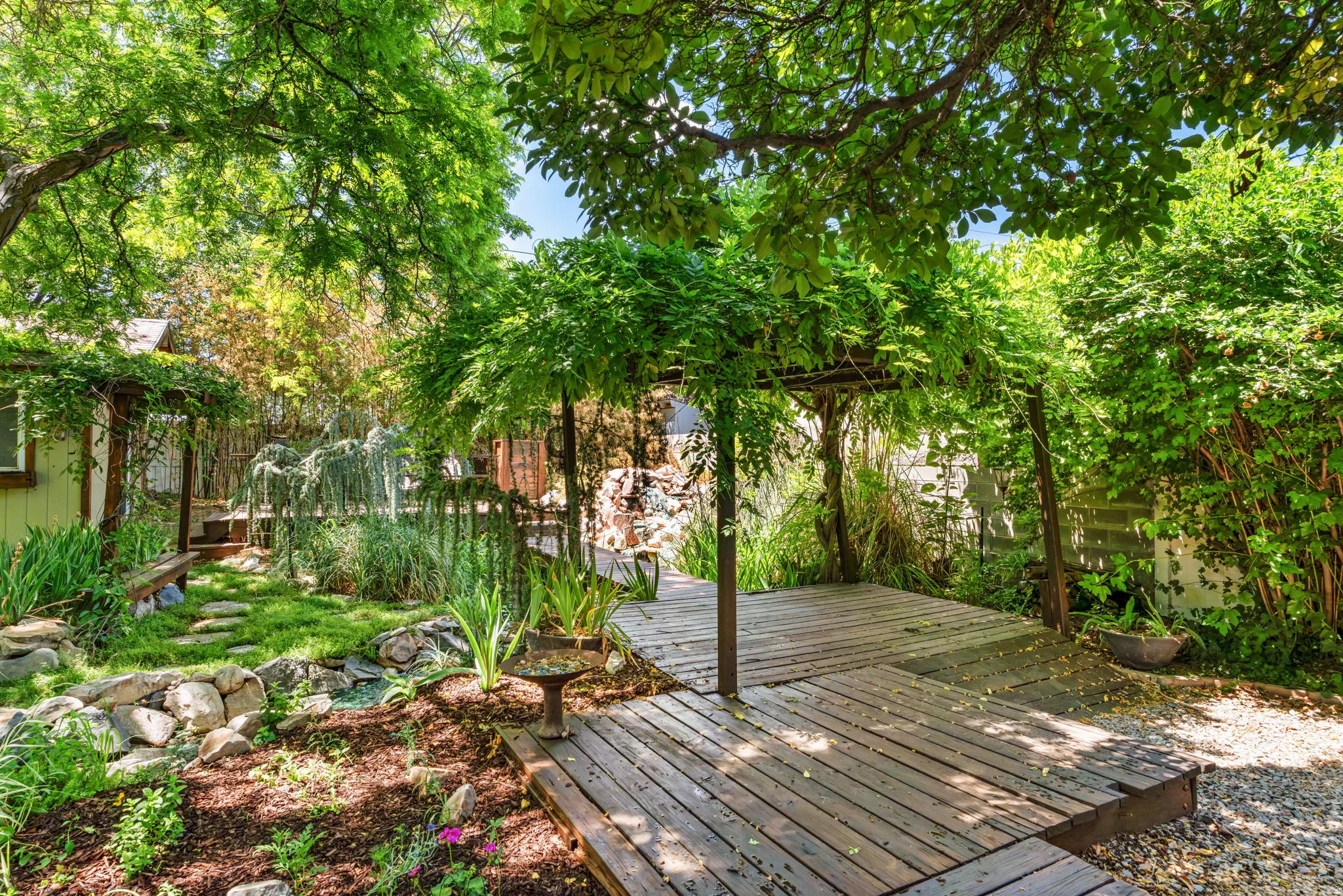 Expansive outdoor deck with a lush overhead vine canopy